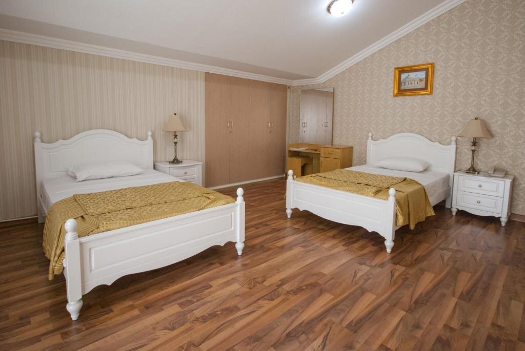 Guest room with wooden flooring and two beds